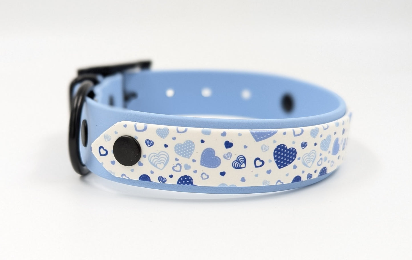 Handmade BioThane dog collar in blue with a layer of UV printed BioThane in cute blue hearts pattern Ireland worldwide close up black hardware