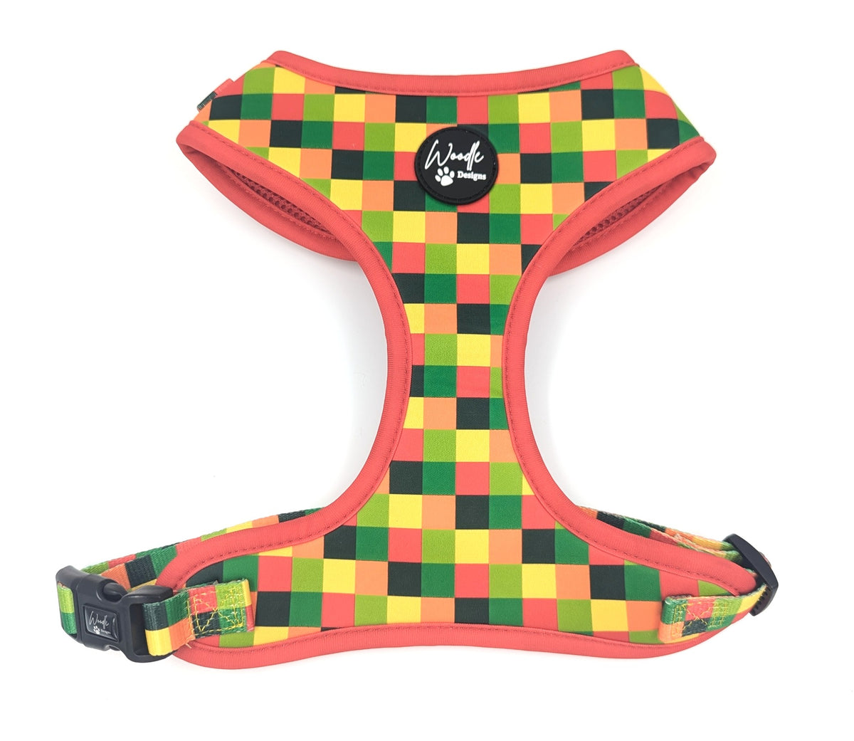An adjustable dog harness with a vibrant multicolor checkered pattern of green, yellow, orange, and black squares, accented with coral red trim and a black plastic buckle. Ireland UK and worldwide. 